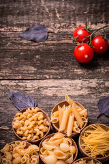 Various mix of pasta on wooden rustic background. Diet and food