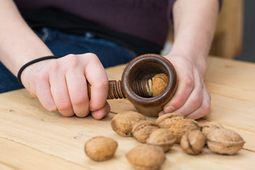 Person mit nostalgischem Nussknacker knackt Walnüsse