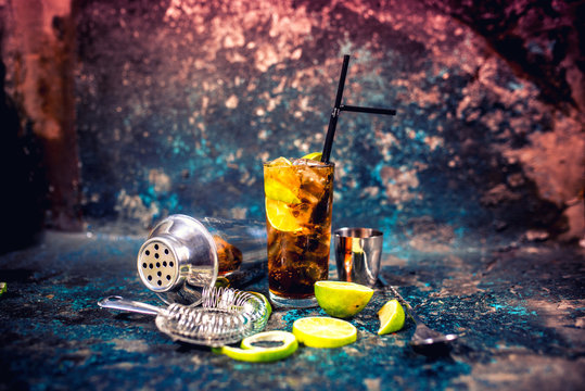 Alcoholic cocktail beverage, cuba libre drink with garnish and metal background