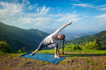 Woman practices yoga asana outdoors
