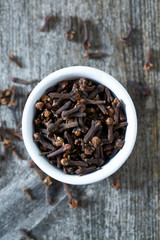 cloves in a bowl on wooden surface