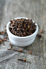 cloves in a bowl on wooden surface