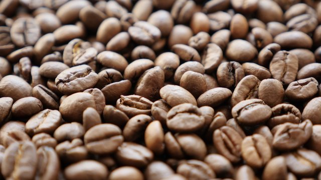 Arabica type coffee beans roasted and arranged slow tilt 4K 2160p 30fps UHD footage - High quality espresso coffee Arabica coffee beans background 4K 3840X2160 UltraHD tilting video 
