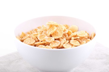 Corn and rice flakes in a cup on a white background