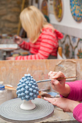 A pottery decorator painting a typical ceramic pine cone in his work table in Caltagirone, Sicily