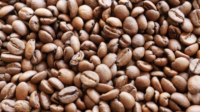 Lot of Arabica type coffee beans roasted and arranged slow tilt 4K 2160p 30fps UHD footage - High quality espresso coffee Arabica coffee beans background 4K 3840X2160 UltraHD tilting video 