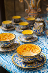 Close up view of a decorated ceramic teacup for sale in the table of a pottery workshop in Caltagirone, Sicily