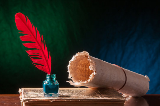 Red quill pen and a backlit papyrus sheet in a blue and green background