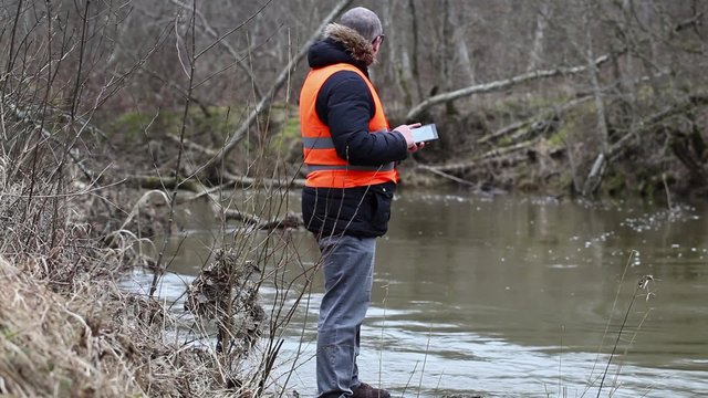 Environmental inspector checks the river pollution in early spring
