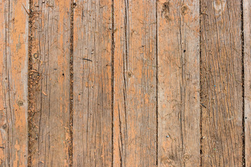 Old weathered wooden fence with rough surface of old brown paint