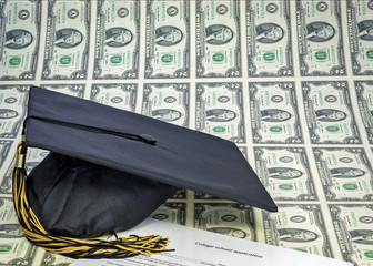 Graduation hat on sheet of uncut money