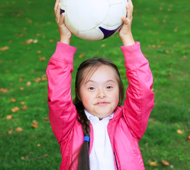 Cute little girl paying in the park with a ball.
