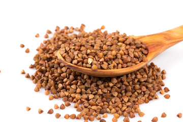 Uncooked buckwheat on wooden spoon