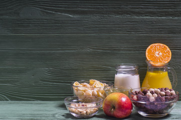 Ingredients for a healthy breakfast: orange juice, yogurt, corn flakes, nuts, honey, tangerines and apples. The concept of a healthy diet, horizontal.