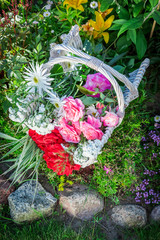 Beautiful flowers in basket in sunny garden