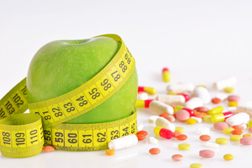 Diet concept - green apples, pills and  measure tape
