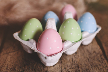 Obraz na płótnie Canvas Easter eggs in nest on wooden background