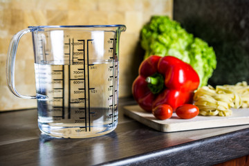 750ccm / 3/4 Liter / 750ml Of Water In A Measuring Cup On A Kitchen Counter With Food