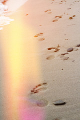 Footprints in the sand. Summer beach holiday vacation concept.  Light leaks film camera effect