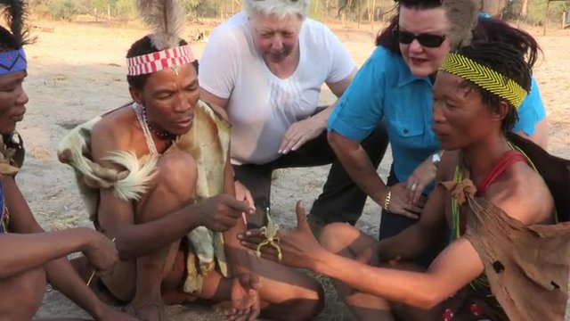 Bushmen showing tourists a scorpion