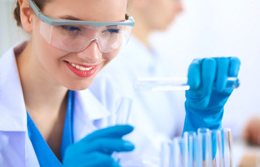 Fototapeta premium Woman researcher is surrounded by medical vials and flasks, isolated on white background