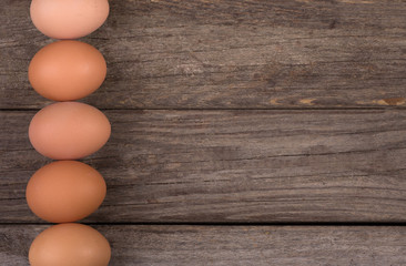 Row of Brown Eggs on a Rustic Wooden Background
