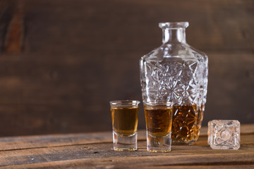 Obraz na płótnie Canvas whiskey in glass on wood background
