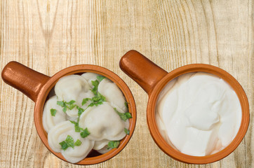 Boiled dumplings and sour cream in the dishes