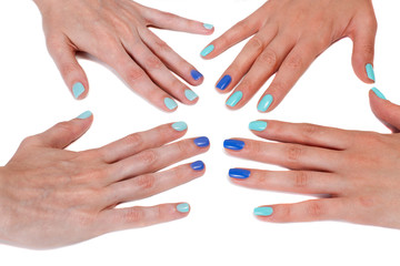 Two pairs of beautiful female hands with blue manicure on white background