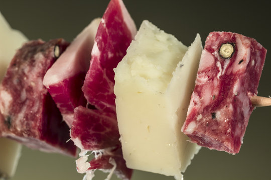 Manchego Curado cheese beside Iberian ham and Iberian salchichón pieces