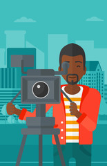 Cameraman with movie camera on a tripod.