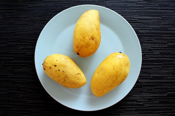 Yellow mango on a mint plate
