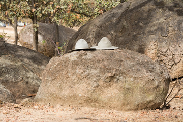 Dos sombreros situados sobre una piedra.
