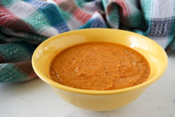 lentil red cream soup in yellow plate