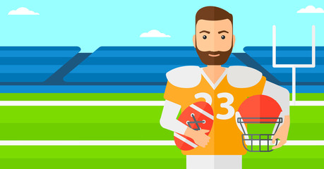 Rugby player with ball and helmet in hands.