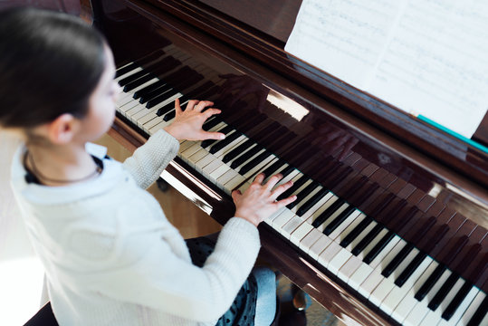 good student plays  piano at a music school