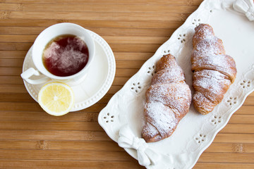 Tea and croissants at wooden table