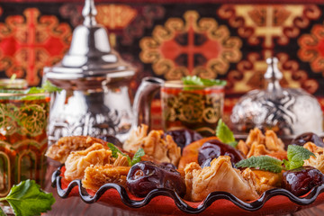 Moroccan mint tea in the traditional glasses with sweets.
