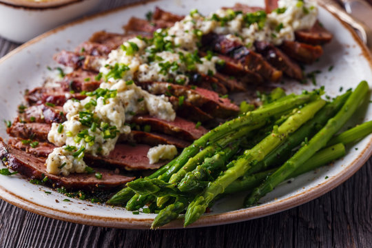 Steak With Blue Cheese Sauce Served With Asparagus.