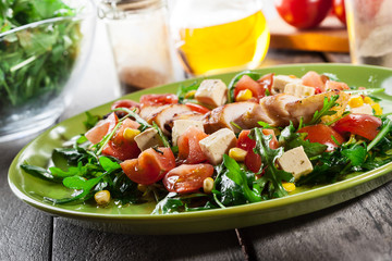 Fresh salad with chicken breast, arugula and tomato