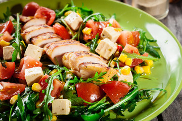 Fresh salad with chicken breast, arugula and tomato