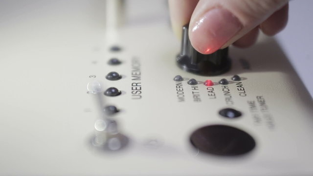 hand adjusting electric guitar amplifier