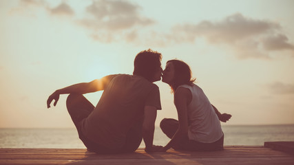 Kissing couple on the tropical sunset background