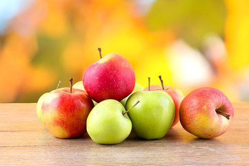 Apples colored, bright wooden background