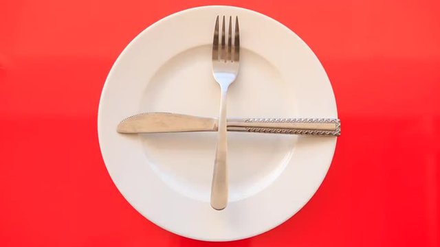 Hands Put Fork Knife Crosswise on Plate on Red Table
