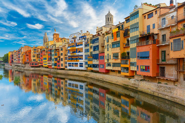 Colorful yellow and orange houses and famous house Casa Maso reflected in water river Onyar, in...