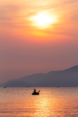 Naklejka na ściany i meble sunset over the sea and a lone fishing boat