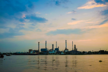 Silhouette of oil refinery factory over sunrise