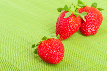 Strawberries, close-up on green background