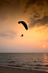 Silhouette paramotor in sunset with Sea View